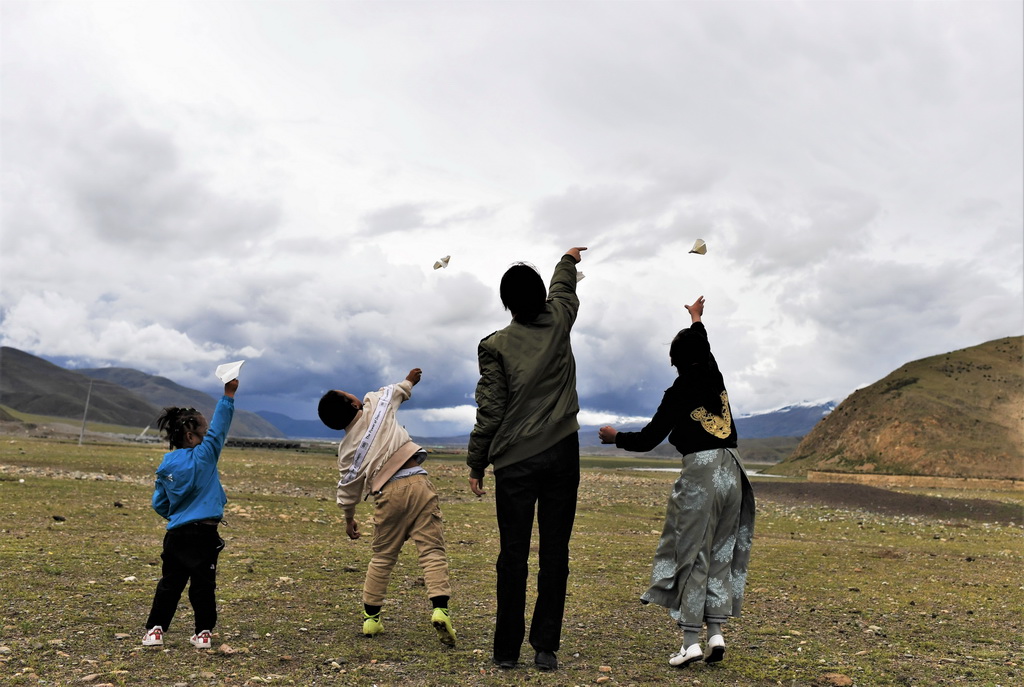 坚热益西（右二）在牧区和弟弟妹妹一起放飞纸飞机（7月13日摄）。新华社记者 普布扎西 摄