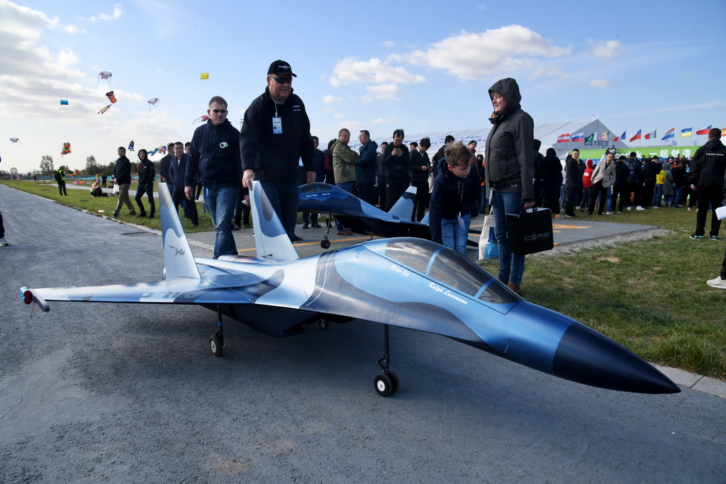 10月14日，一名参加开幕式表演的选手将模型飞机推上跑道。