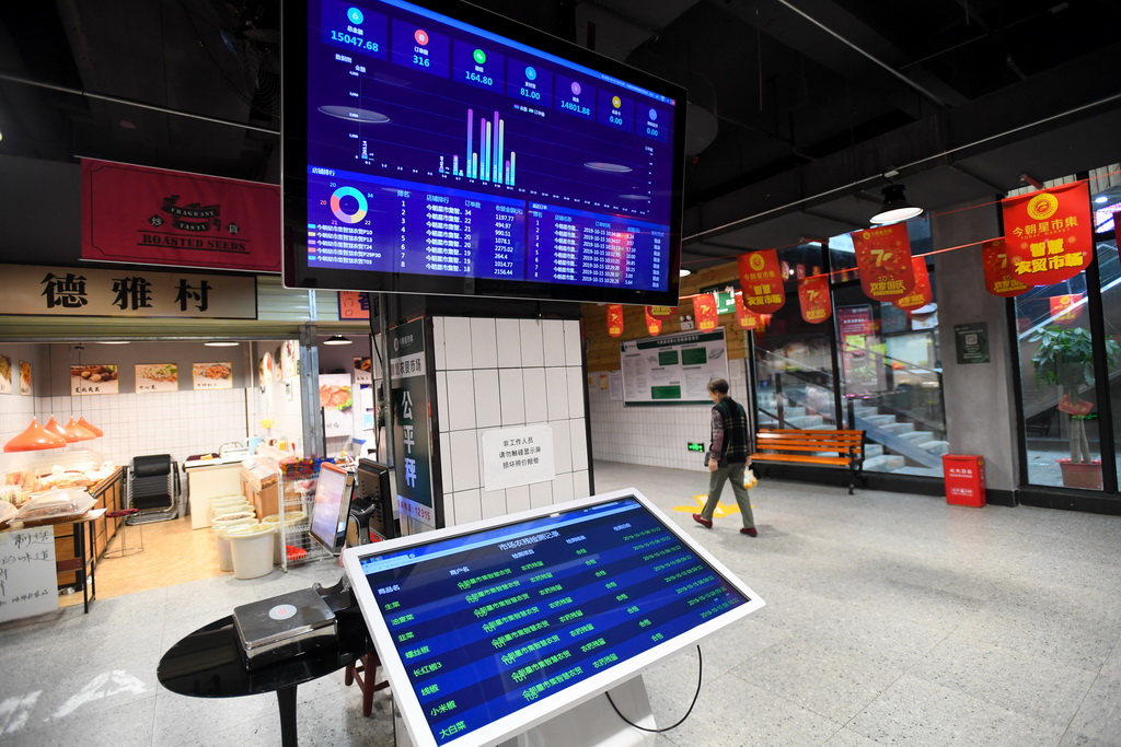 今朝星市集智慧农贸市场的销售数据和菜品农药残留检测记录通过市场大厅里的电子屏幕实时显示（10月15日摄）。