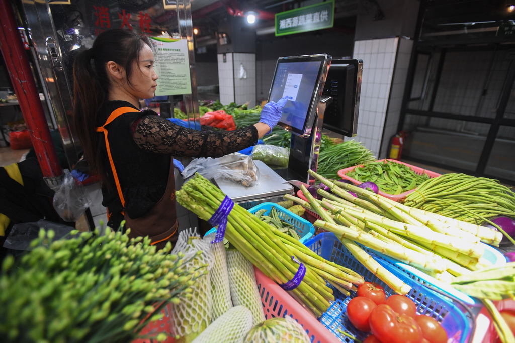 10月15日，今朝星市集智慧农贸市场的蔬菜经营户在操作电子结算系统。