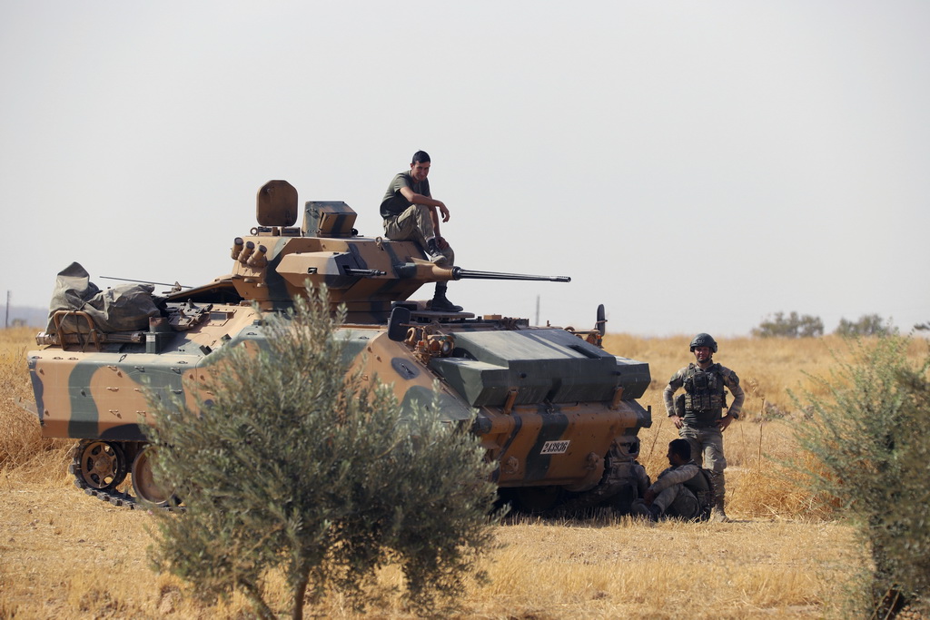 10月14日，在敘利亞北部重鎮曼比季，土耳其軍人在一輛裝甲車旁休息。新華社/美聯