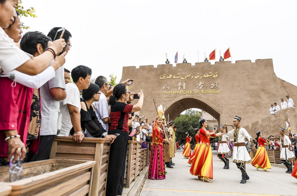 在新疆喀什古城景區“開城”儀式上，游客在觀看歌舞表演（8月13日攝）。