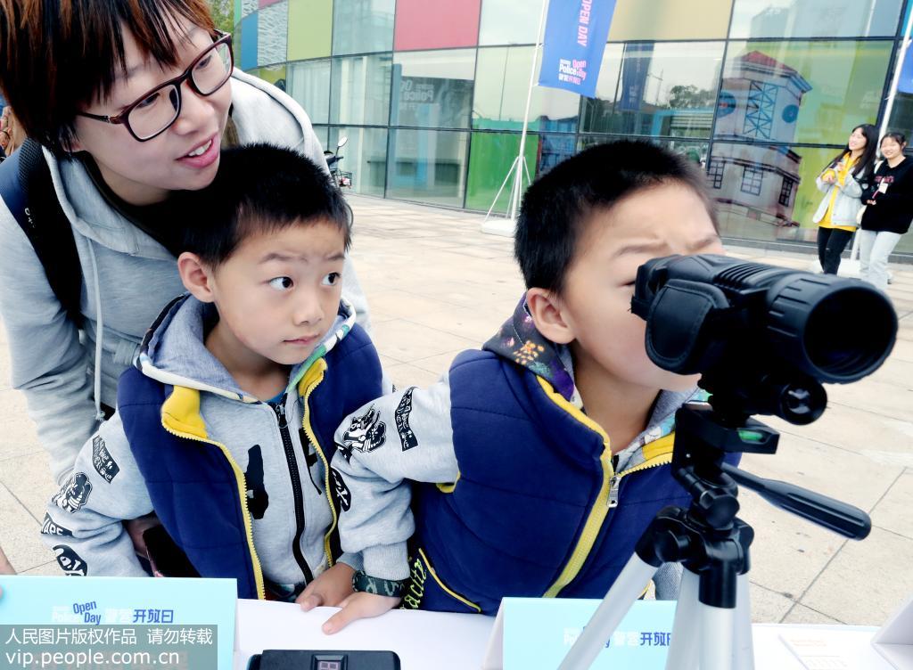 11月23日，一位蘇州家長帶著雙胞胎孩子正在觀看警用夜視儀。