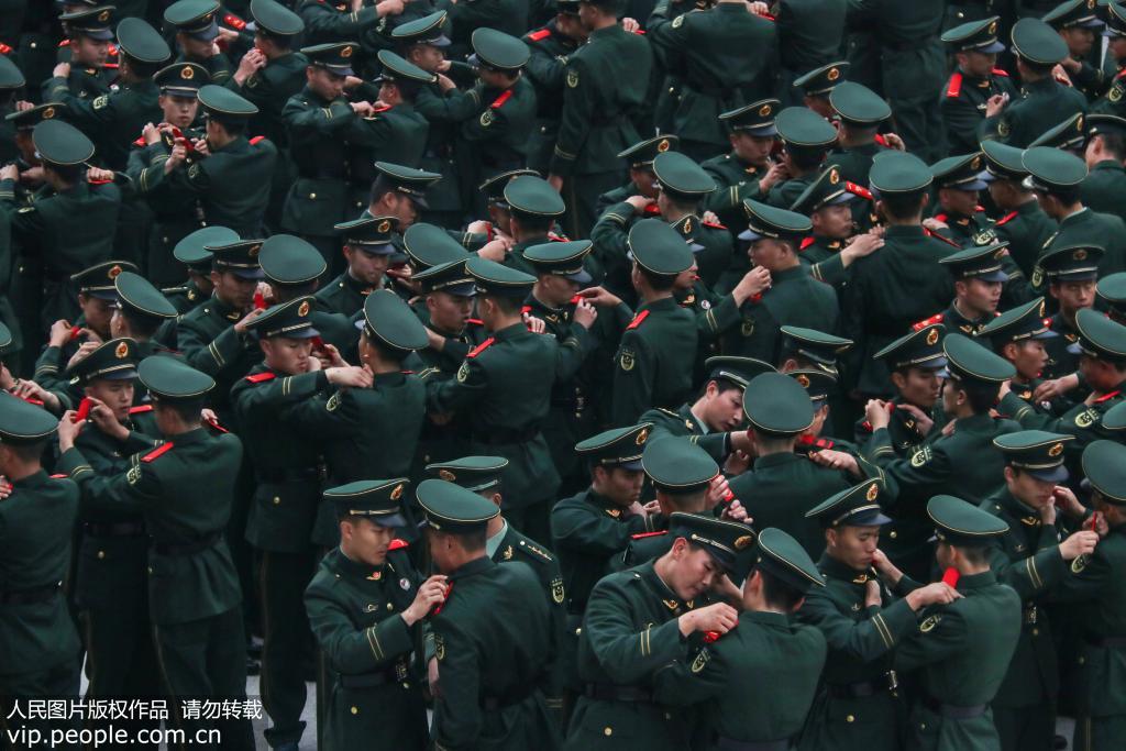 12月12日，武警重慶總隊新兵團的新兵們正在互相佩戴肩章。