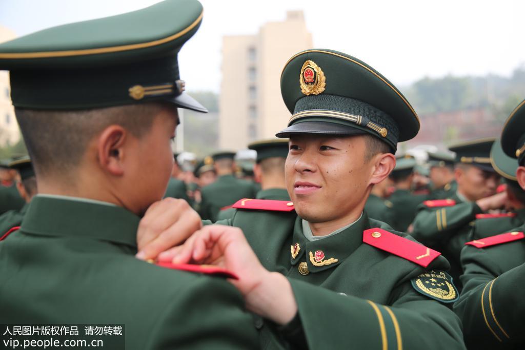 12月12日，武警重慶總隊新兵團的新兵們正在互相佩戴肩章。