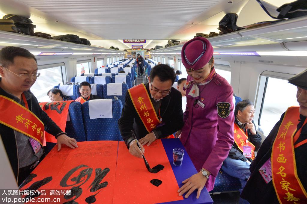 12月16日，貴州省書法家在開往成都南的C6008次動車上為旅客書寫福字。喬啟明/人民圖片