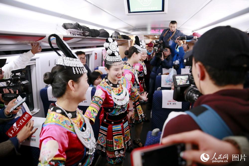 12月16日，在成都東開往貴陽北的C6041次首發動車組列車上，成都“動妹”身著苗族服飾，歡快舞蹈。（李鍇 攝）
