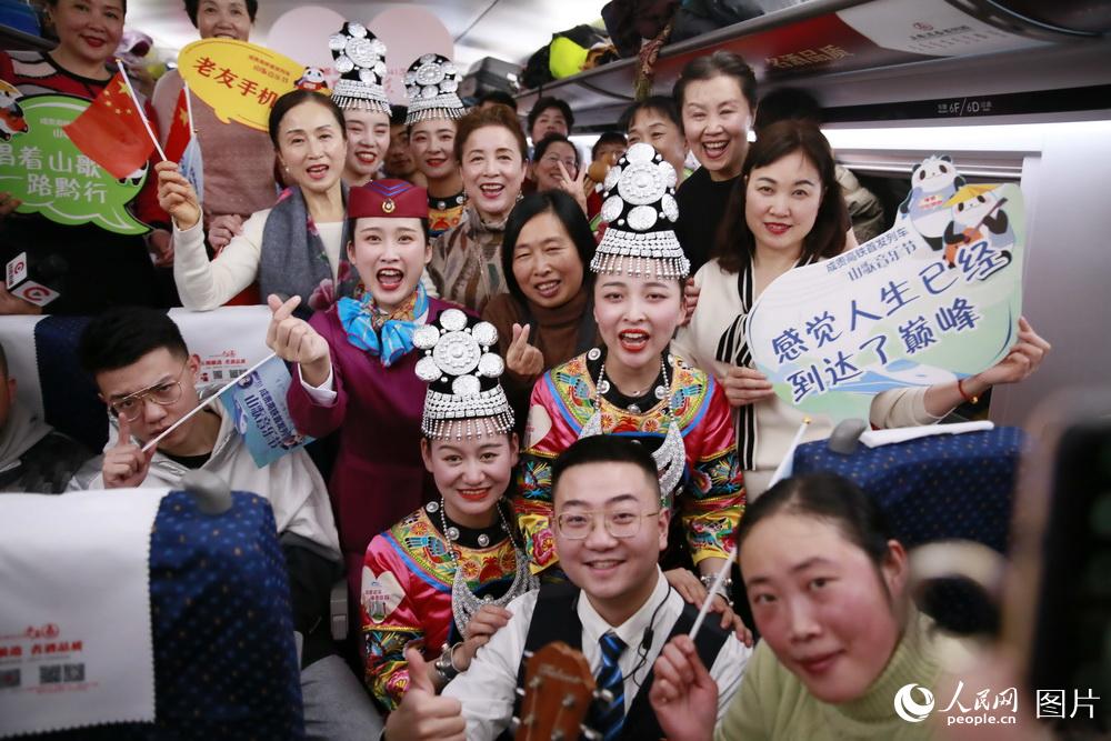 12月16日，在成都東開往貴陽北的C6041次首發動車組列車上，成都客運段工作人員與旅客合影留念。（李鍇 攝）