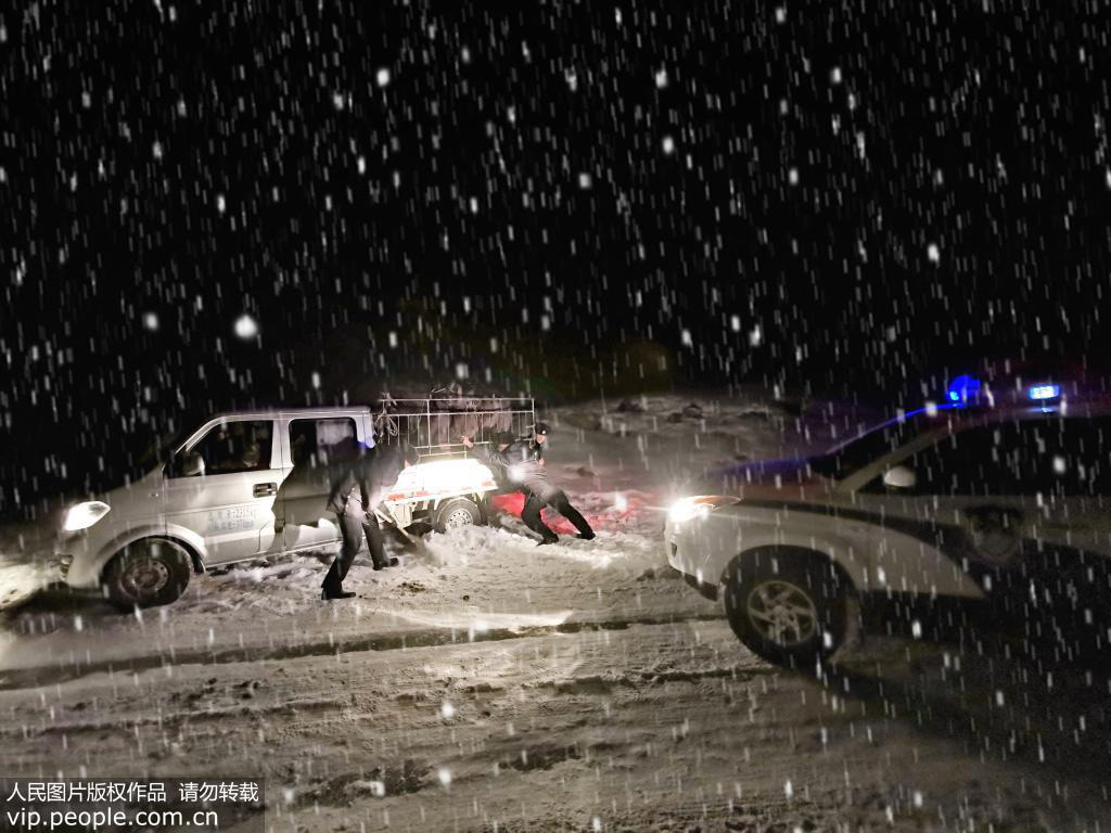 12月17日，新疆阿勒泰邊境管理支隊阿熱勒邊境派出所民警正在幫助群眾解決受困車輛。