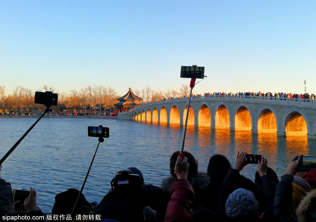 北京頤和園再現“金光穿洞”美景 吸引游客競相爭拍人氣火爆
