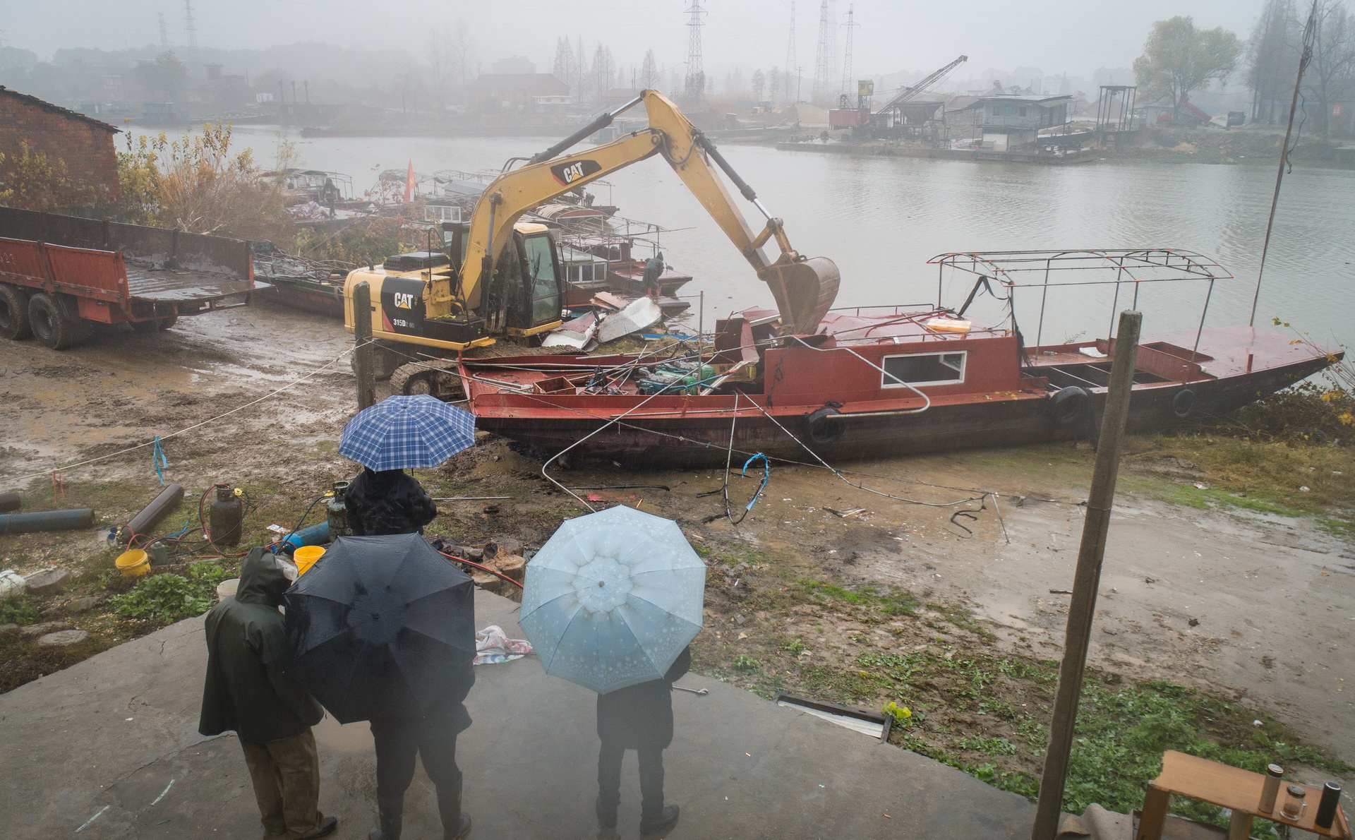在長江新螺段白鱀豚國家級自然保護區漁船拆解現場，漁民在一旁觀看正在被拆解的漁船（2019年12月25日攝）。