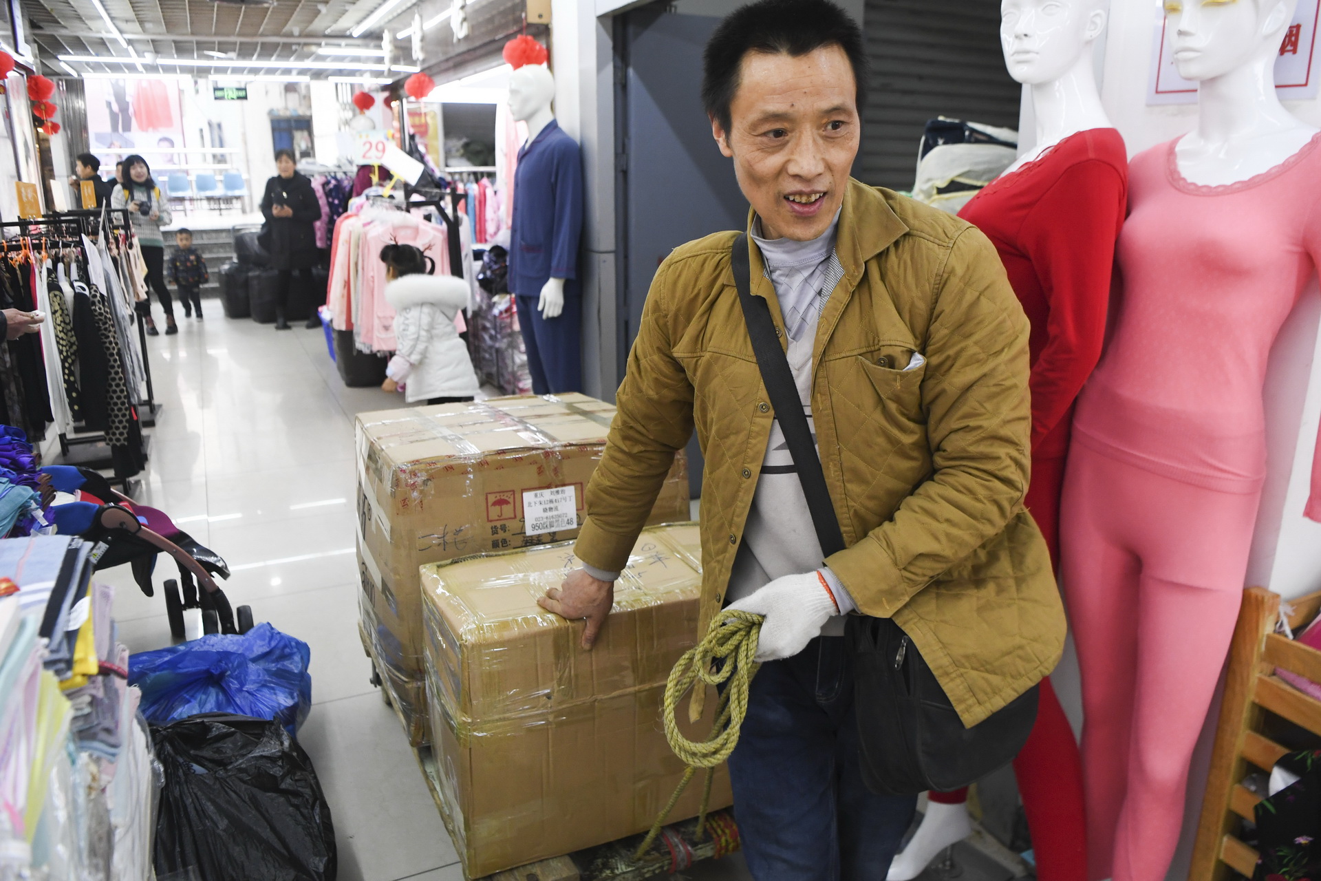  冉光輝在重慶朝天門大正商場內搬運貨物（1月5日攝）。