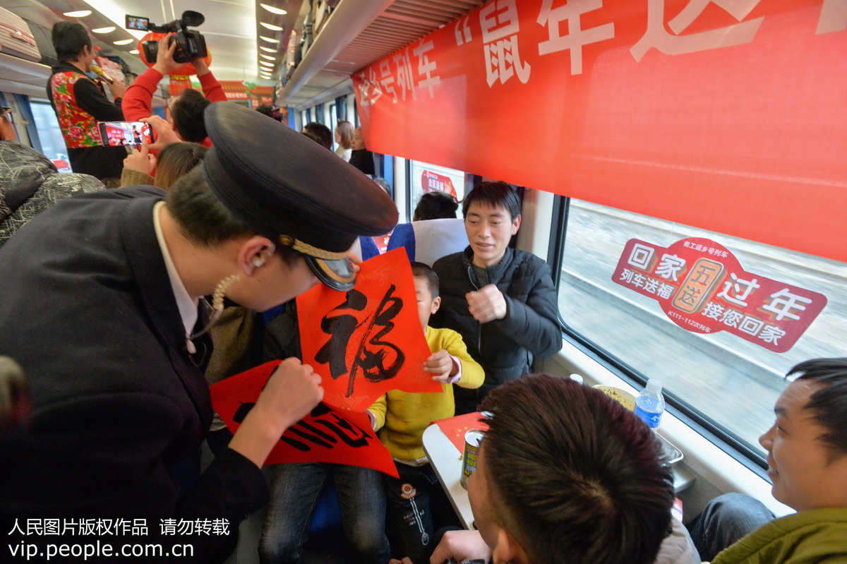 1月14日，上海南-貴陽K111次列車的乘務員在車廂內給外出務工人員贈送書法家書寫的福字。