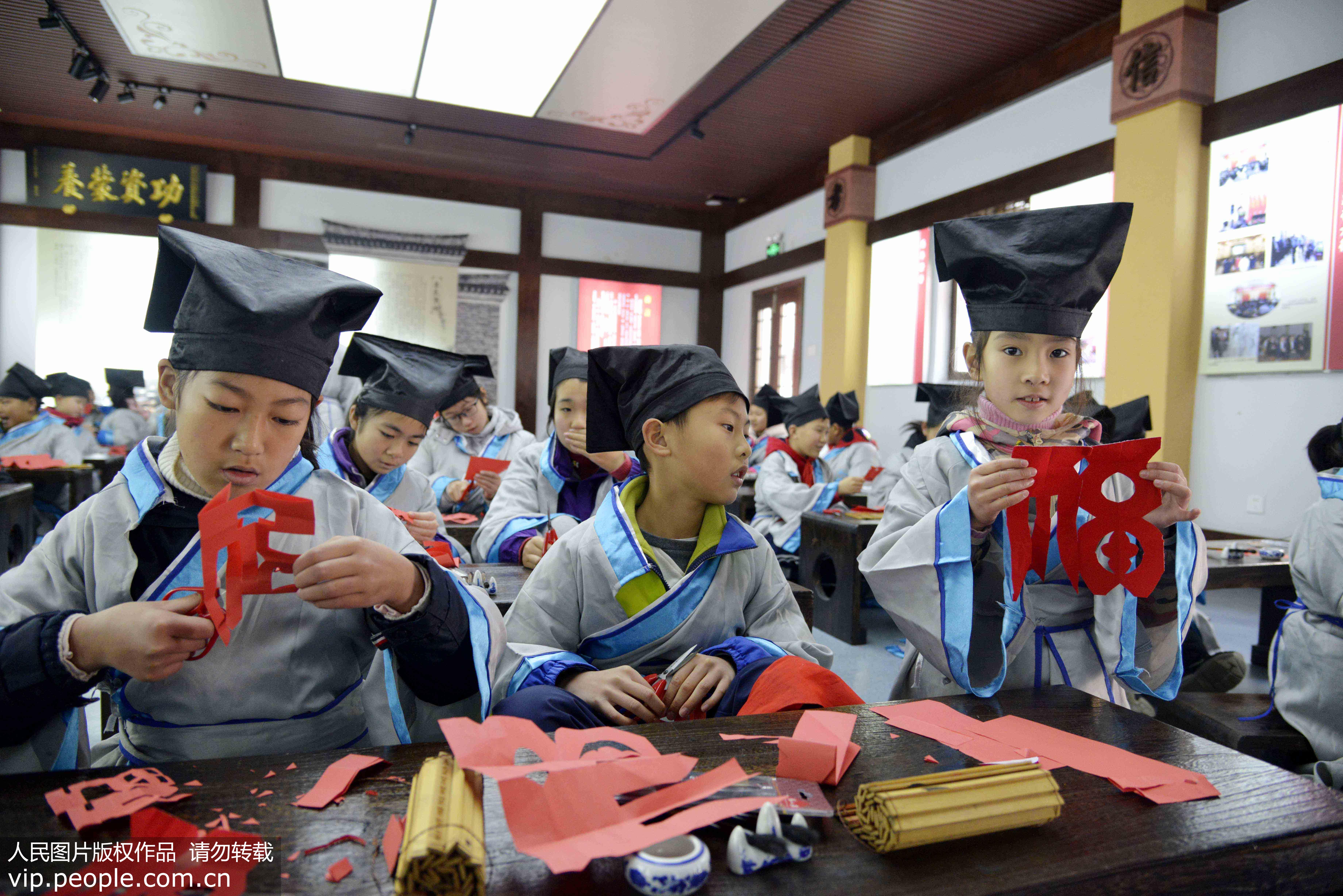 1月13日，浙江省舟山市定海區環南街道少年冬令營學子在體驗民俗剪紙。