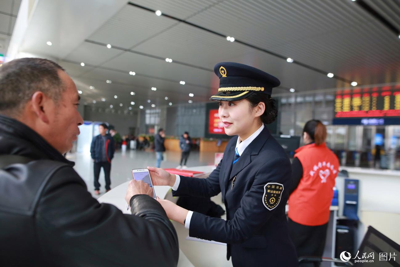 图为刘佩晗在服务台为旅客解疑答惑。