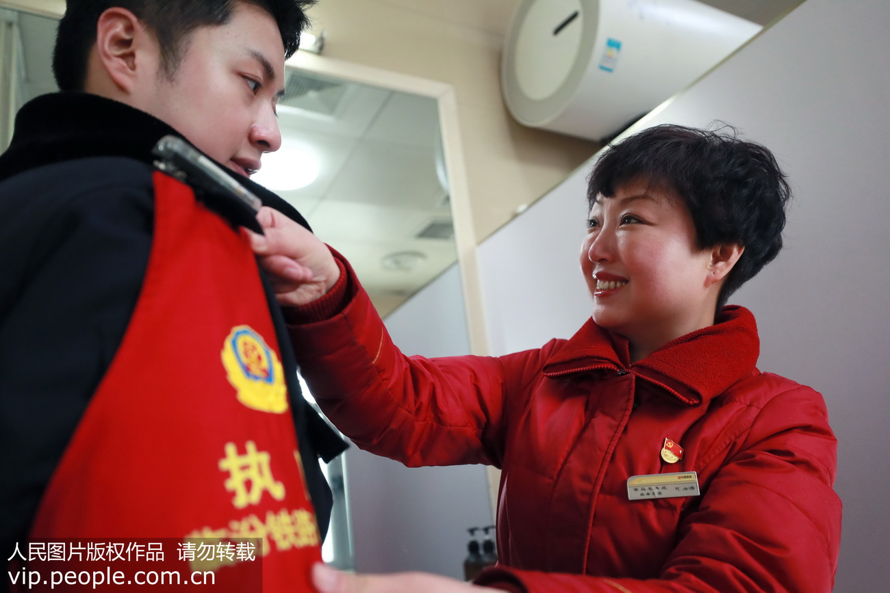 2020年1月21日，臨汾西站（山西），臨汾鐵路公安處民警李永浩上崗前，母親陳海濤為其整理警容風紀。