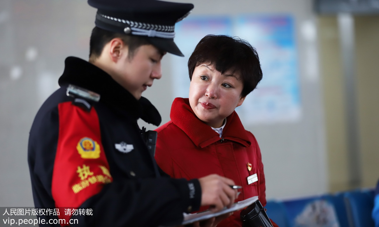 2020年1月21日，臨汾西站（山西），臨汾鐵路公安處民警李永浩和母親陳海濤在旅客中間進行客票調查工作。