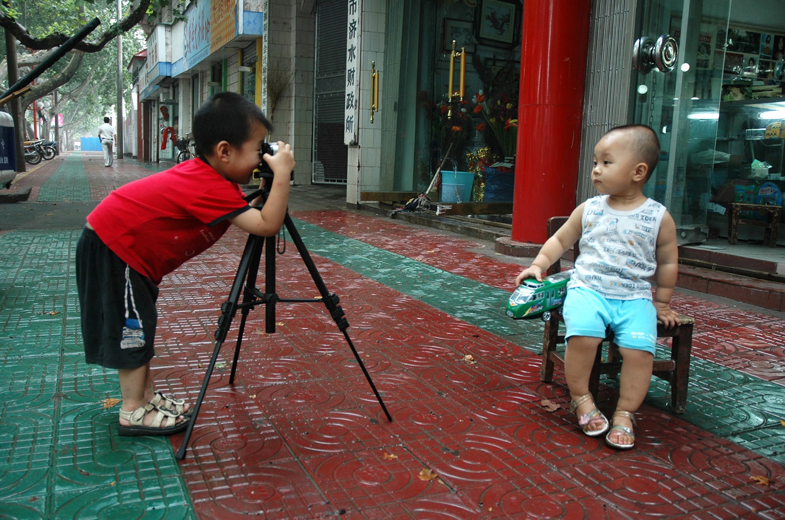 楊錦洋(高中組)河南《笑一笑》 弟弟拿著爸爸送的相機有模有樣的給小朋友拍照。搜索復制