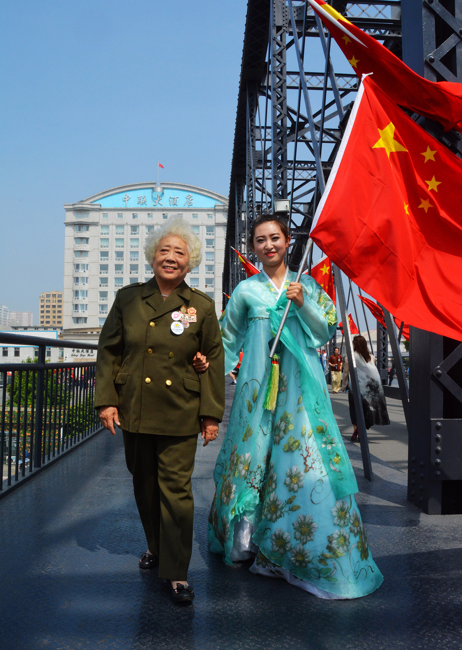 聶文婷(高中組)遼寧《崢嶸歲月》 朝鮮族姐姐手握五星紅旗跟隨軍人奶奶來到鴨綠江大橋祭奠抗美援朝犧牲的戰士。搜索復制