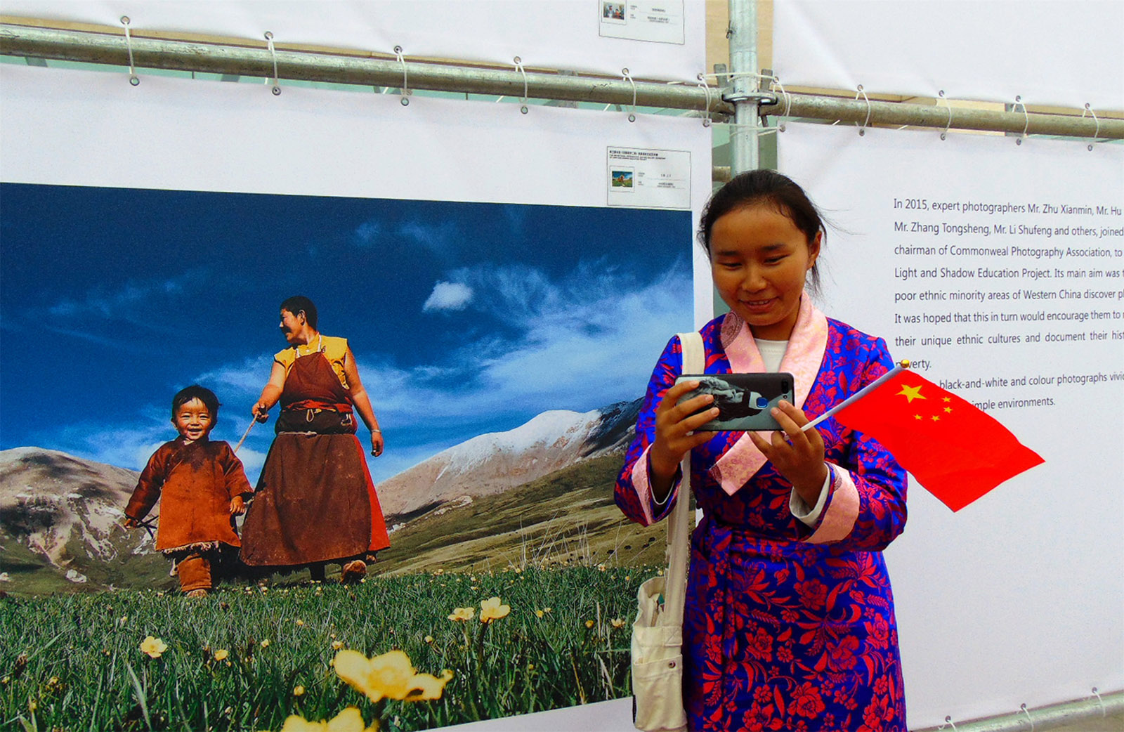 強巴卓嘎(高中組)西藏《將北京攝影展作品傳給家人》 2019北京國際攝影周期間，藏族學生在光影助學工程工委會統一組織下，來到北京中華世紀壇全國第三屆光影助學工程展館，藏族學生用手機拍一張自己與反映藏民生活攝影作品的照片，發給家人分享她的快樂。搜索復制