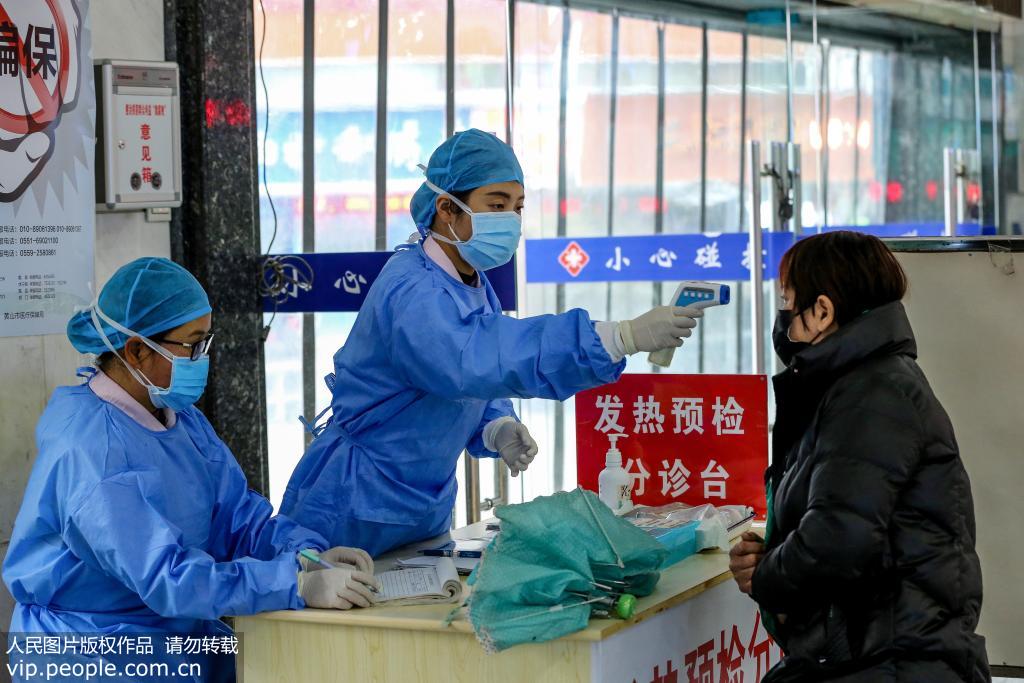 1月25日，安徽省黃山市人民醫院醫務人員在給來醫院做體溫發熱檢查的市民做體溫測量。作者：吳孫民