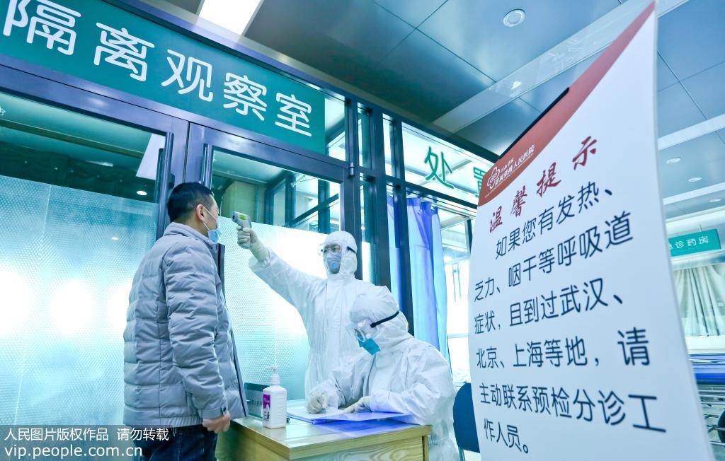 1月26日，甘肅張掖河西學院附屬醫院的發熱門診的預診區內醫務人員正在給發熱病人測量體溫和做好登記工作。作者：王將