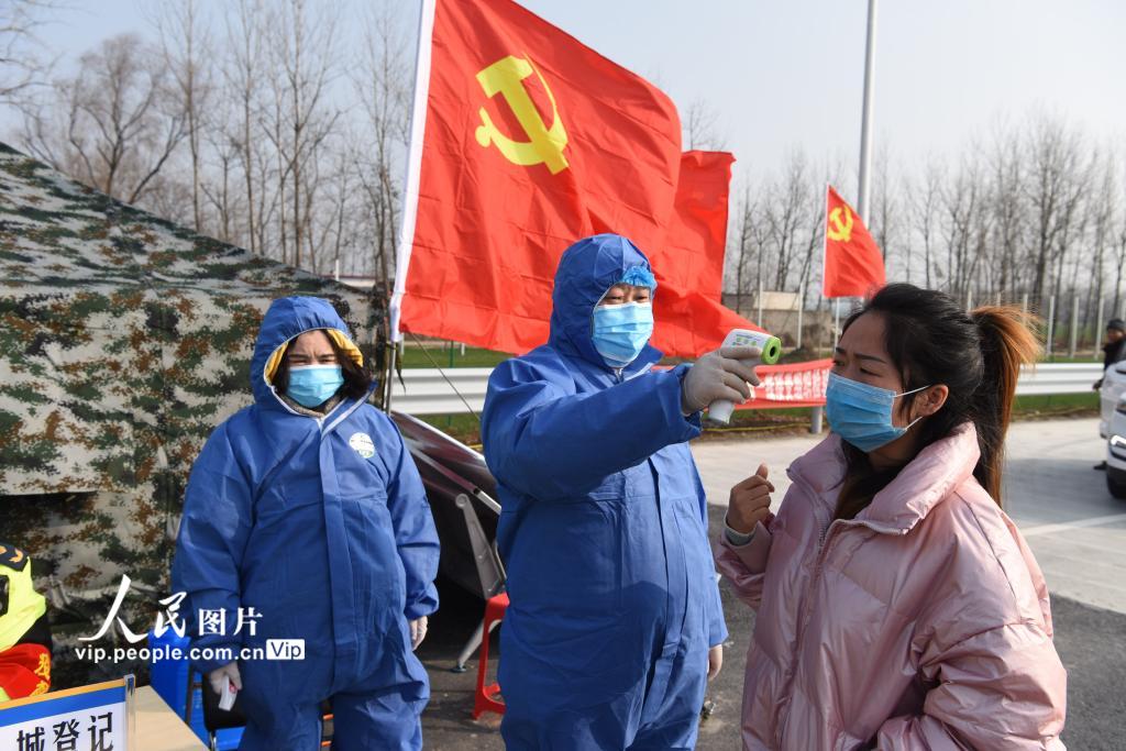 1月29日，在息邢高速河南省正陽站，正陽縣黨員志願者正在檢測出入人員體溫。（高萬寶  人民圖片）