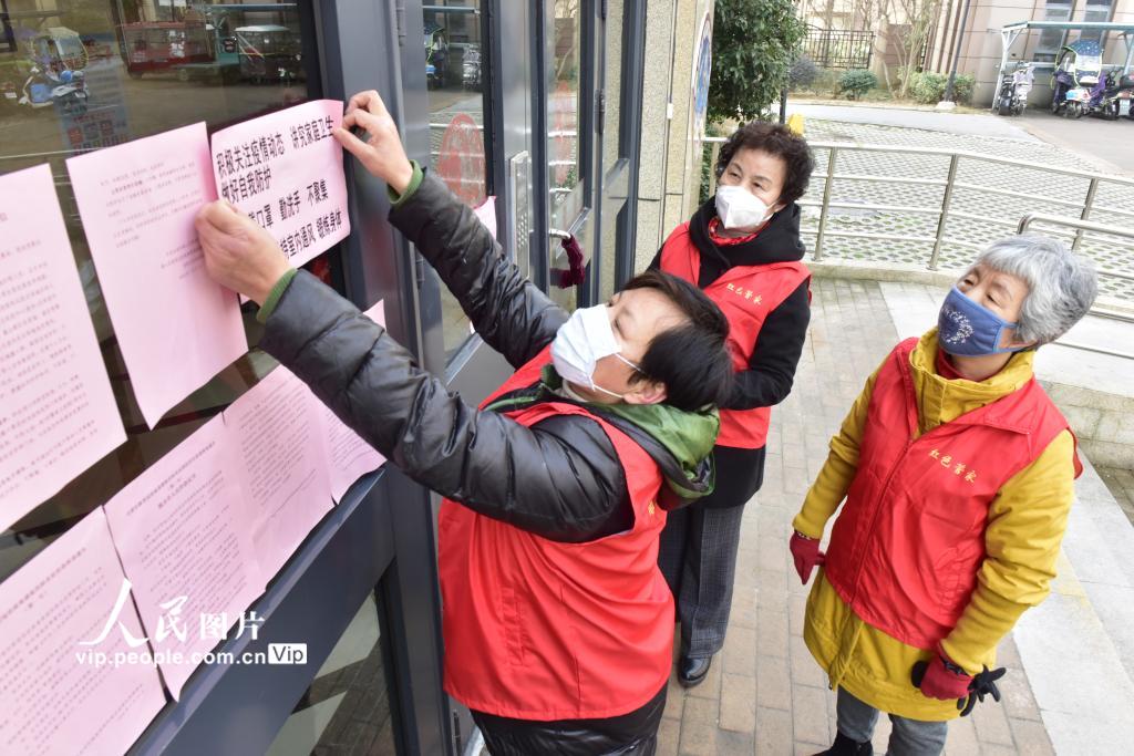 1月30日，合肥一小區裡的“紅色管家”在樓棟出入口張貼疫情防控溫馨提示標語。（葛宜年  人民圖片）
