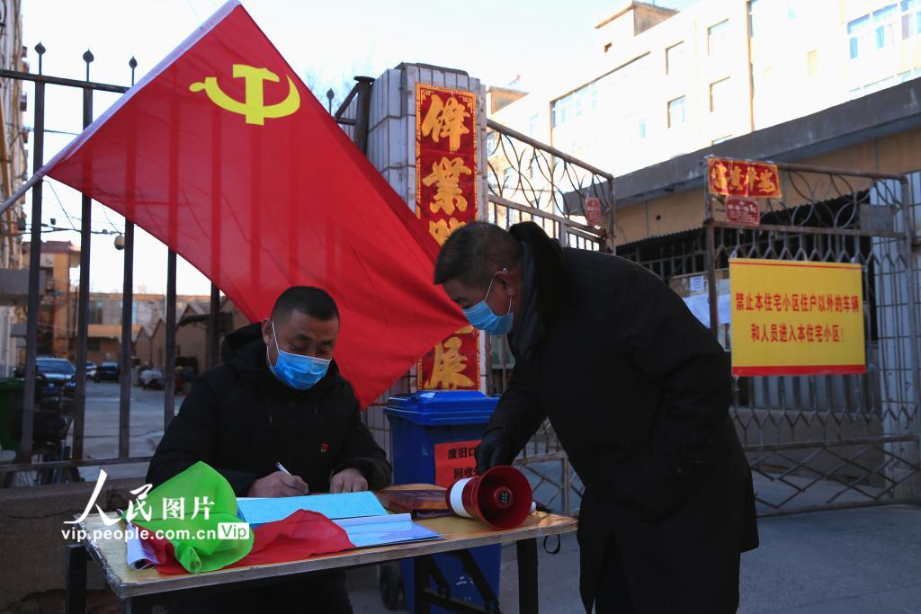 1月30日，甘肅張掖金沙小區共產黨員正在為居民辦理進出小區通行証。（楊永偉  人民圖片）