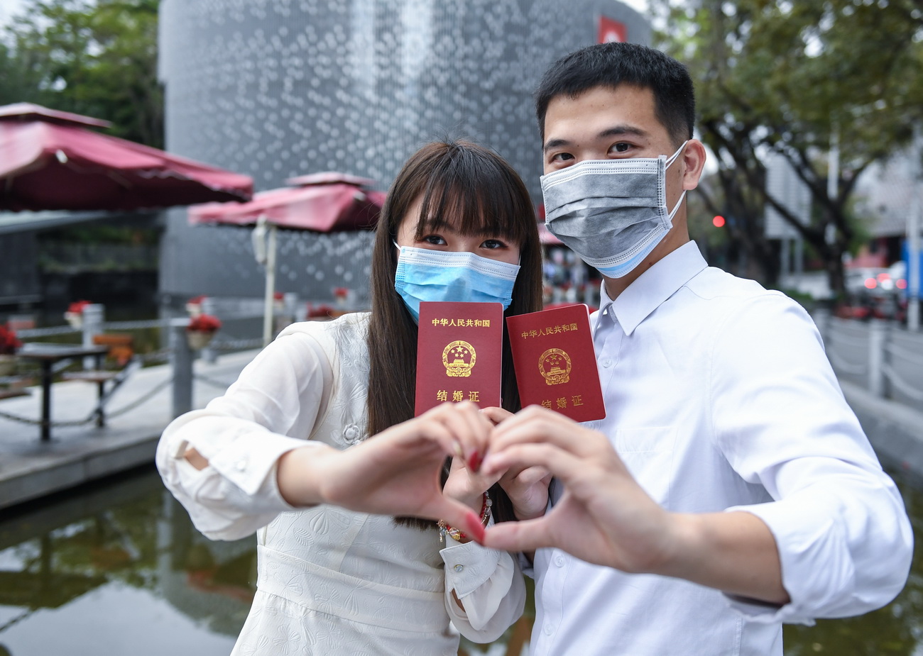2月14日，完成結婚登記的張鈴雯（左）和黃苗煒在深圳市南山區民政局婚姻登記處前合影。