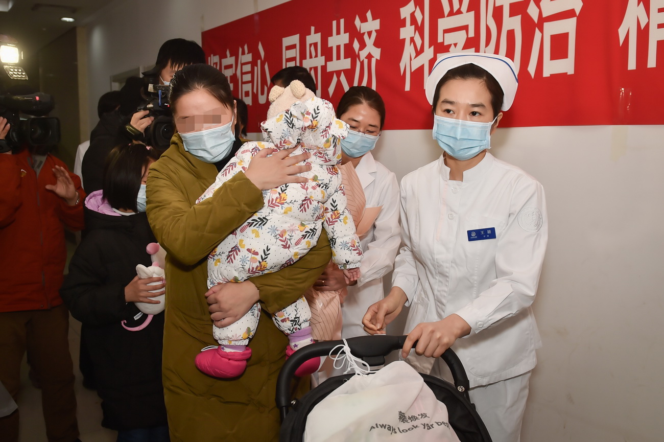 2月14日，护士长王颖（右一）送奇奇（化名）一家人离开医院。新华社发（彭子洋 摄）