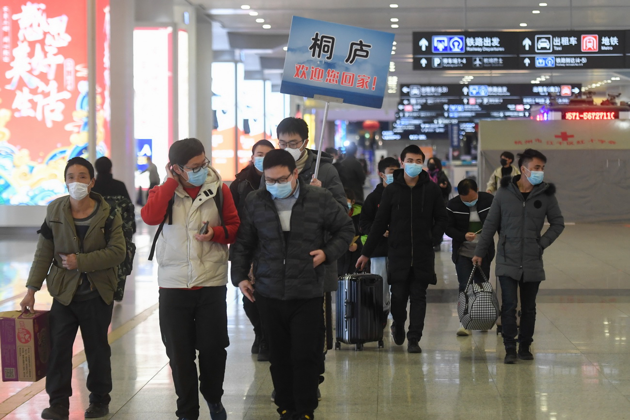 在杭州东站，从贵州乘坐外地复工人员专列抵达杭州的复工人员出站后准备直接乘坐企业的包车离开（2月16日摄）。