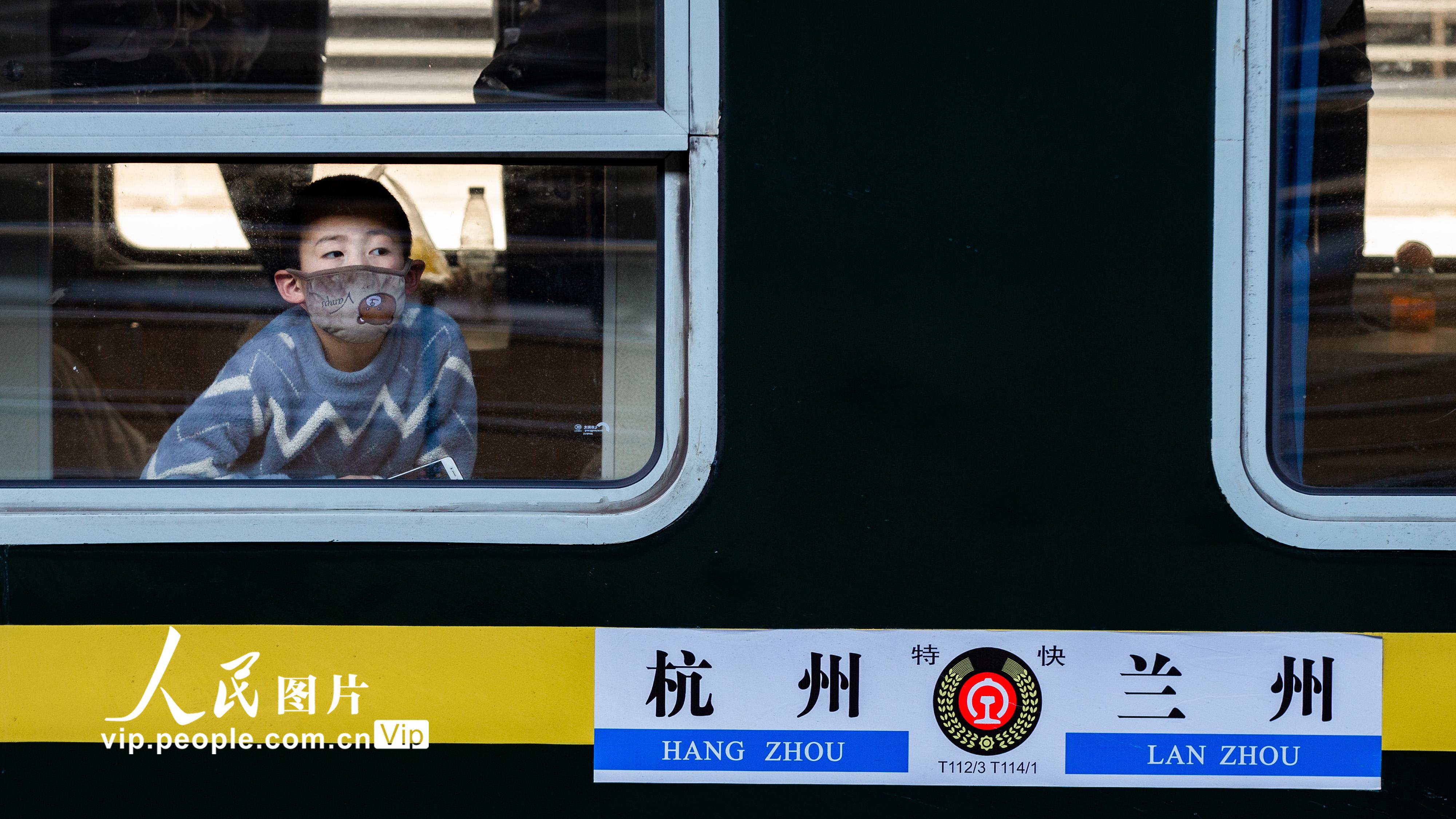 2月18日，在南京火车站，一名小朋友透过列车车窗向外张望。