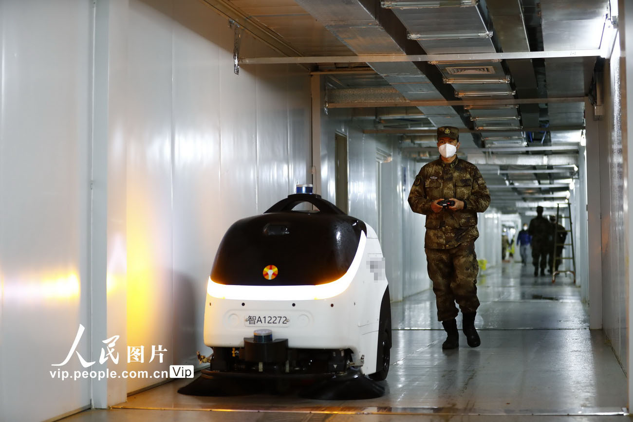 2月26日，武漢火神山醫院，洗消分隊隊長張鵬飛在操控機器人對走廊進行消毒作業。