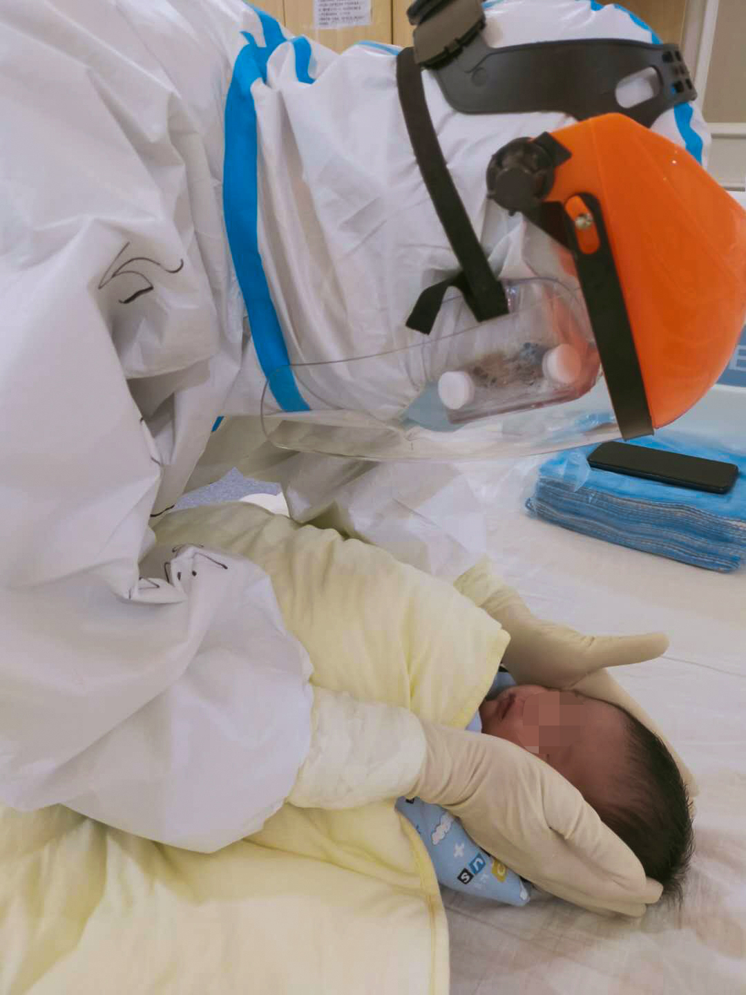 在湖北省潛江市婦幼保健院，蘇卉在給點點採集完咽拭子后安撫她（2月21日攝）。