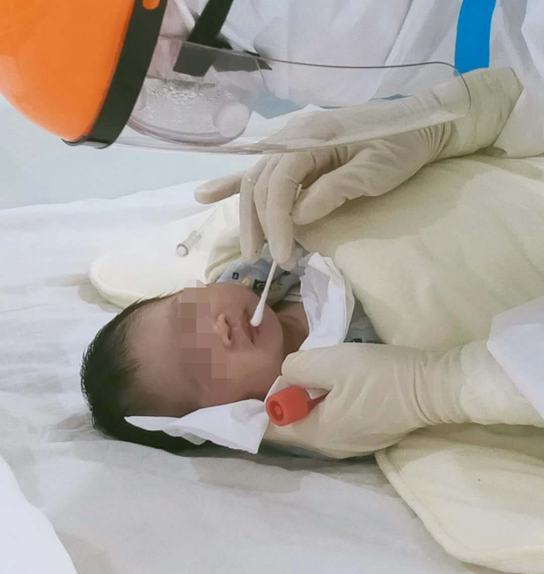 在湖北省潛江市婦幼保健院，蘇卉給點點採集咽拭子（2月21日攝）。