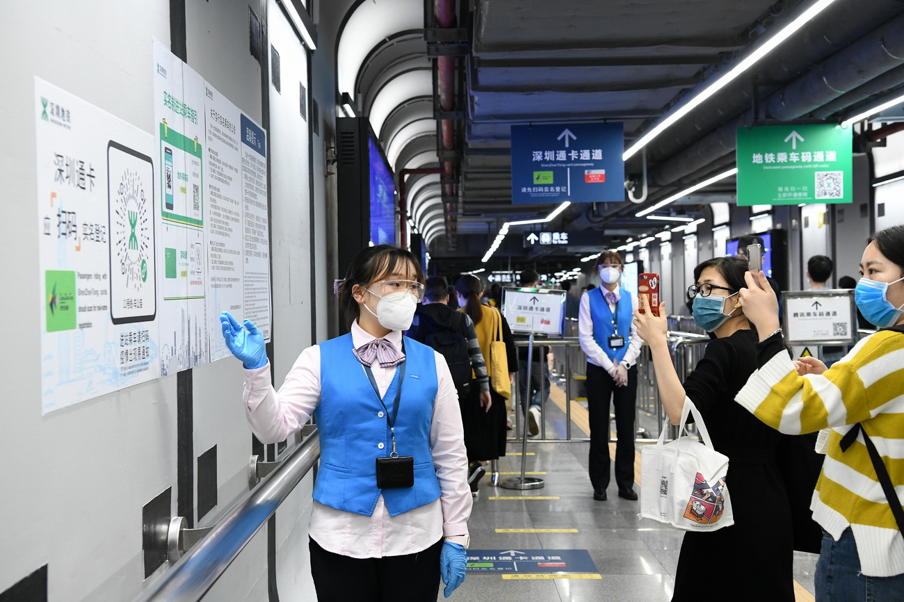 3月18日晚高峰時段，在深圳地鐵車公廟站，乘客掃描二維碼進行實名登記。