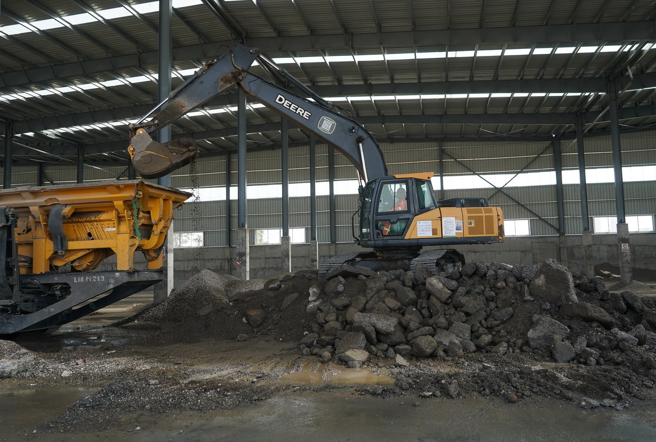 3月18日，工人在循環利用基地操作機械，將舊路廢料加工成再生混合料的原材料。