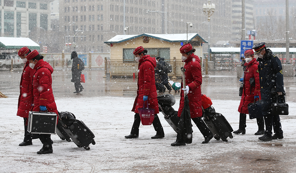 12.2月2日，列車員冒雪走進北京站。鄒紅攝影