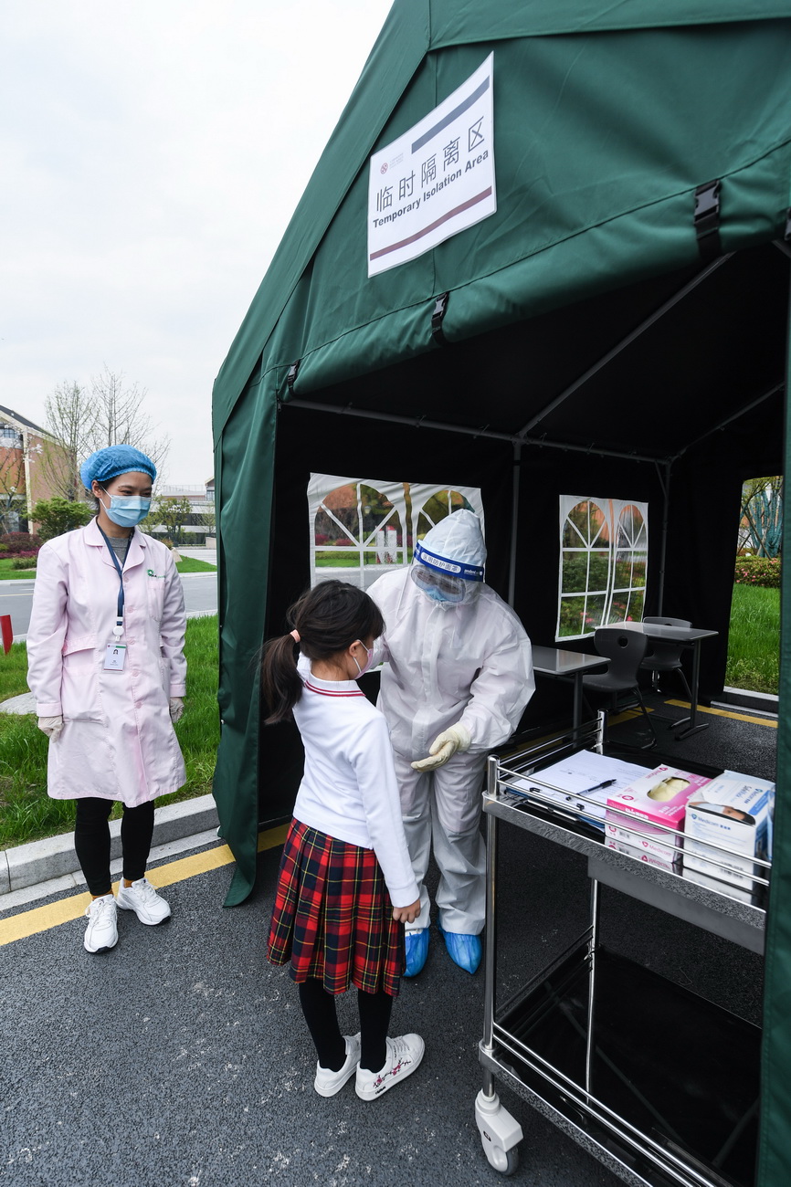  3月26日，在人大附中杭州學校防疫演練中，醫護人員在臨時隔離區對體溫“異常”的學生進行二次測溫。
