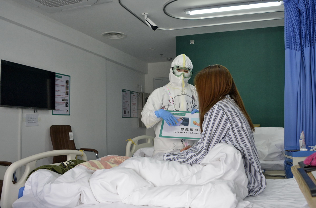 3月30日，北京小湯山定點醫院的醫護人員在和患者交流。 新華社發（陳鐘昊 攝）