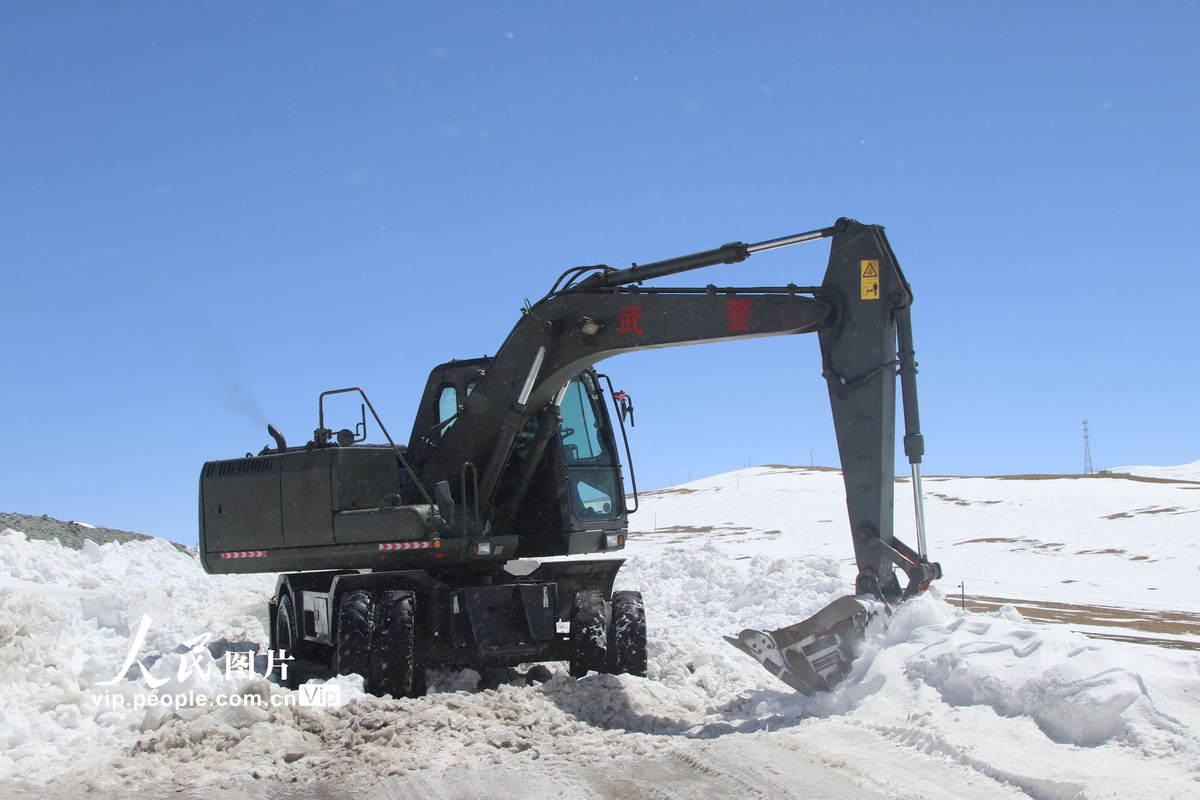 4月4日，武警官兵操作挖掘機在國道219線馬攸木拉達坂路段進行破冰清雪。