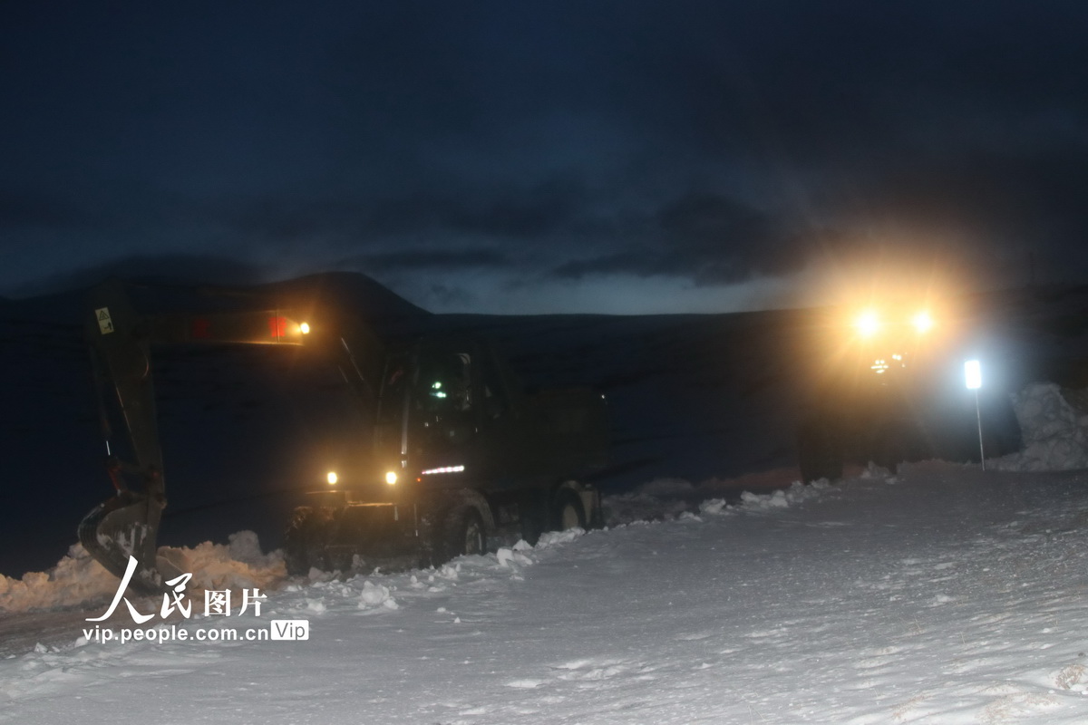 4月4日夜間，武警官兵操作挖掘機、裝載機在國道219線馬攸木拉達坂路段進行破冰清雪。
