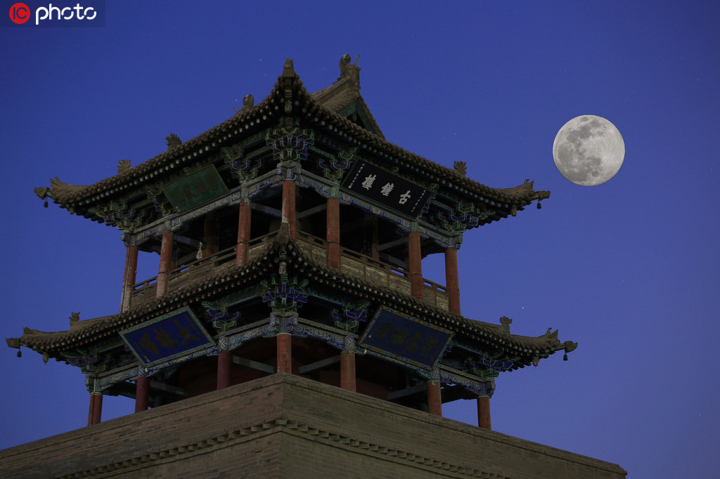 4月7日19時38分左右，在甘肅省武威市大雲寺前拍攝的“超級月亮”（二底合成）。姜愛平/IC photo