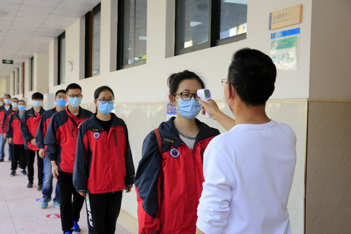 4月15日，在重慶市北碚區朝陽中學南校區，參加演練的教師們在熟悉進入教室測量體溫環節。