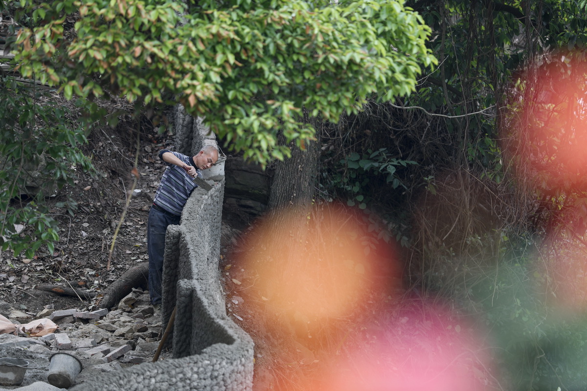 4月16日，在重庆市南岸区铜锣花谷生态园，工人在修筑堡坎。