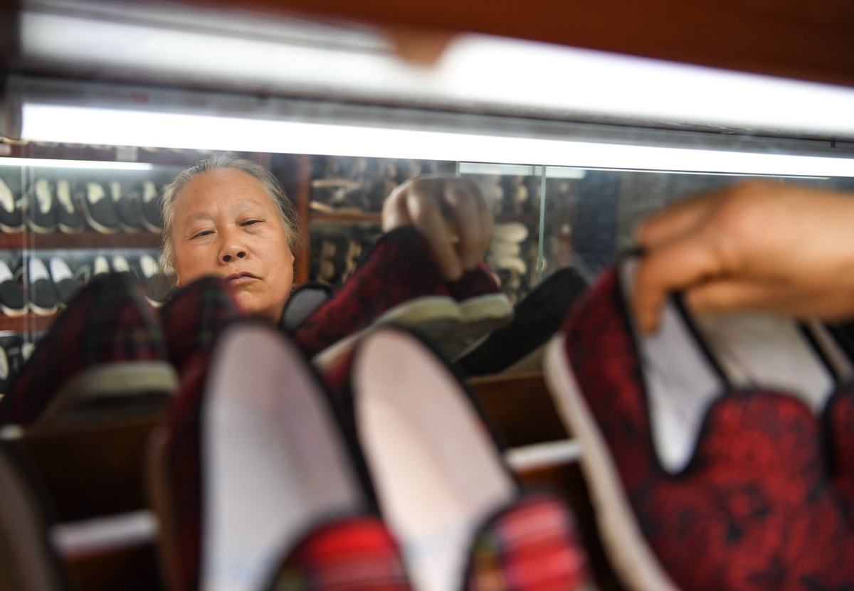 4月16日，在戰旗村，賴淑芳在整理展示櫃裡的布鞋。