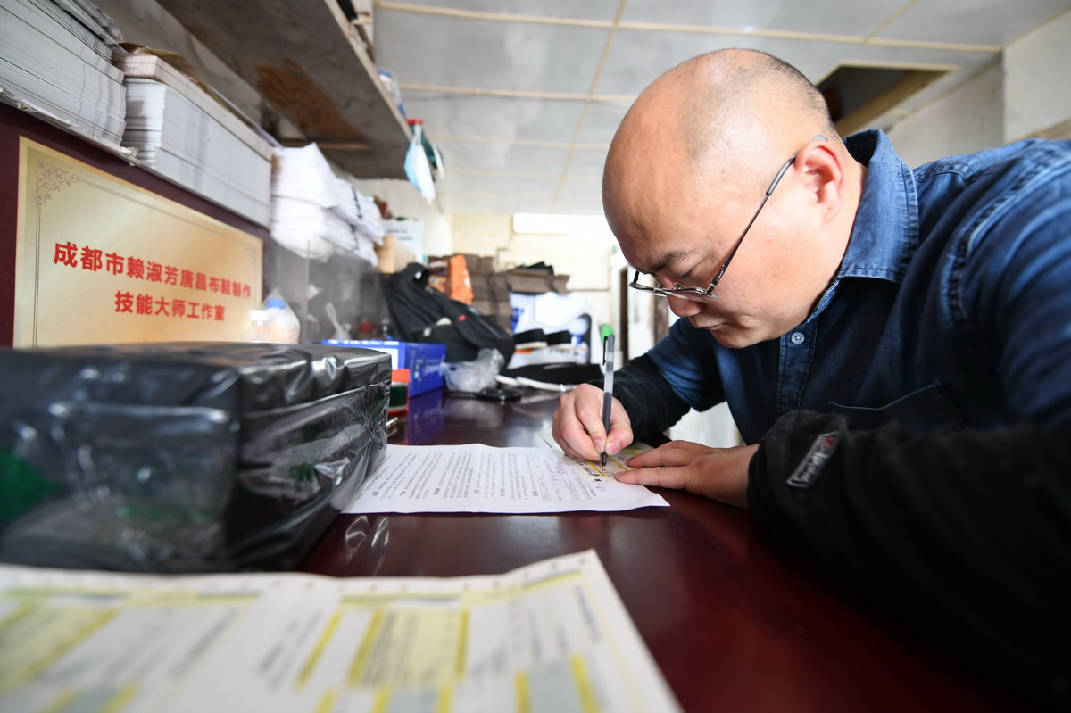 4月17日，在唐昌鎮，賴淑芳的兒子艾鵬在填寫快遞單准備發貨。