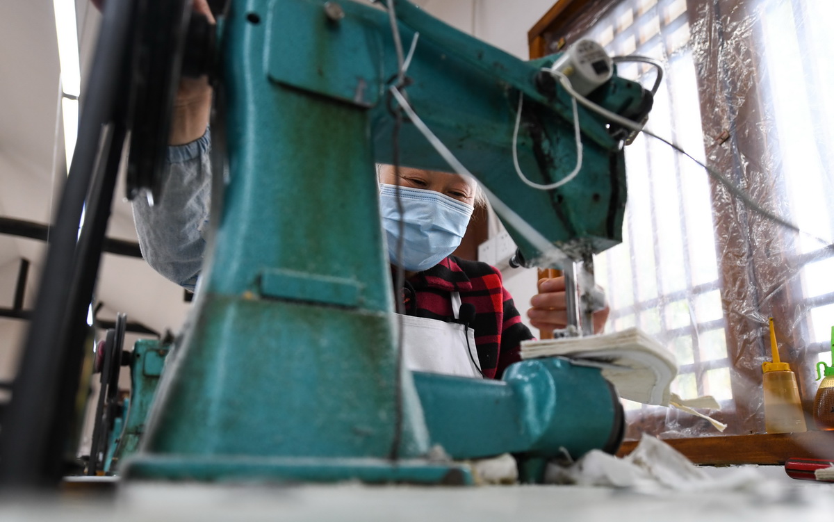 4月17日，在戰旗村，賴淑芳使用縫紉機給布鞋納底。