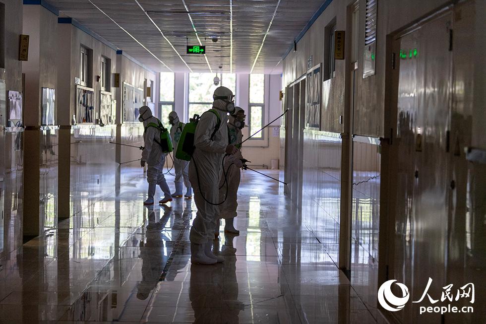 4月24日，消毒防疫人員正在噴洒生物酶制劑，對教學樓走廊進行生物清潔。（人民網記者 翁奇羽 攝）